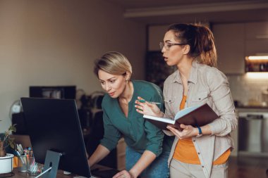 Evde çalışırken konuşan iki kadın serbest yazar. İnternette toplantı yapıyorlar..