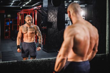 Spor salonunda spor yaptıktan sonra aynanın önünde poz veren genç kaslı bir vücut geliştiriciyi vurmuşlar..