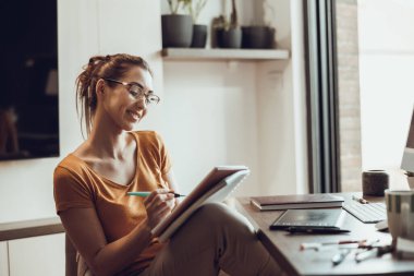 Evinde çalışan yaratıcı genç bir kadın..