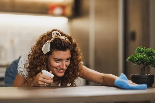 Mujer Sonriente Desinfectando Limpiando Una Superficie Mesa Mientras Hace Tareas —  Fotos de Stock