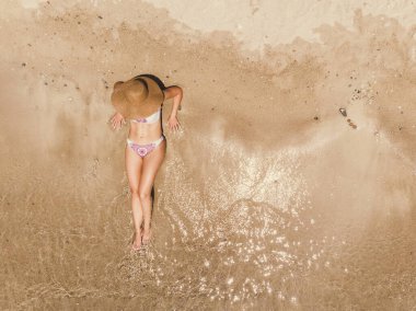 Sahilde güneşlenirken bikini giymiş güzel bir kadının manzarası. Tropik açık deniz dalgalarında dinleniyor..