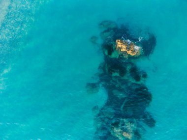 Etrafı kayalarla çevrili güzel kristal berrak turkuaz deniz suyunun hava manzarası.. 