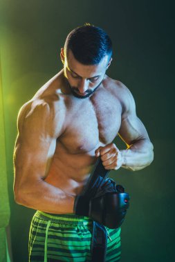 Boks yaptıktan sonra kaslı üstsüz bir adamın mükemmel kaslarını gösteren bir stüdyo fotoğrafı..