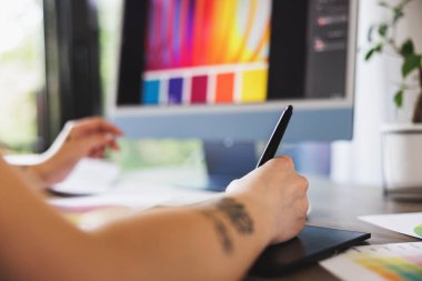 Ev stüdyosunda bilgisayar üzerinde çalışan tanınmayan bir tasarımcının yakın plan fotoğrafı..