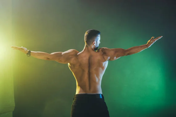 年轻的肌肉健美运动员在运动后摆姿势时表现出完美肌肉的后视镜 — 图库照片
