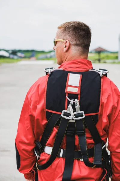 タンデムジャンプ パッキング チェック装置の準備をしながらベルトを締め付けるパラシュターのリアビュー — ストック写真