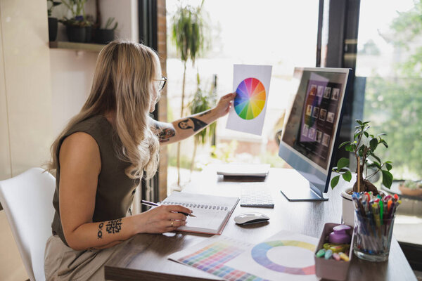 Творческая молодая женщина выглядит заботливой, работая в своей домашней студии.