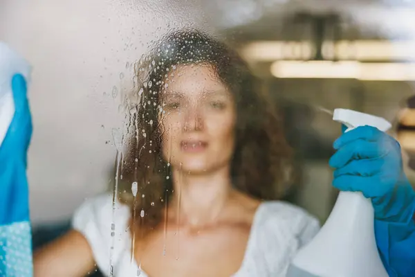 Femme Nettoyage Vitre Avec Chiffon Pulvérisation Pour Hygiène Des Bactéries Image En Vente