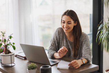 Genç bayan girişimci ev ofisinden internet üzerinden toplantı yapıyor..