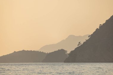 Doğanın arka planında dağlar olan panoramik okyanus