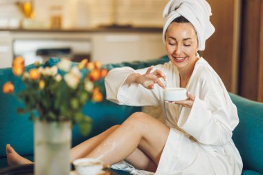 Çekici bir kadın evinde sabahtan zevk alırken bacaklarına bakıyor..