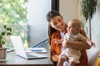 Shot of a young mother caring for her baby girl while working from home.