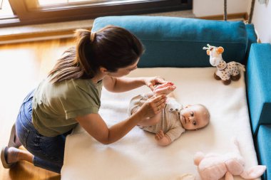 Genç bir annenin, sevimli bebeğine evde bakması..