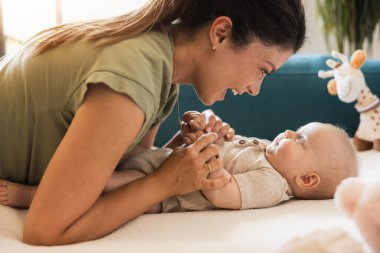 Genç anne evde tatlı bebeğiyle eğleniyor ve eğleniyor..