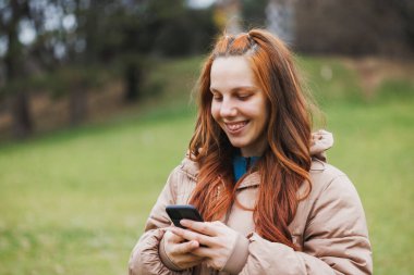 Bir kadın, dijital içerikle bağlantı kurmak için cep telefonunu kullanıyor..