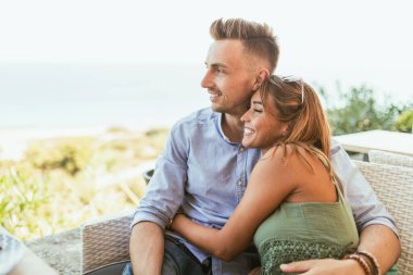 Güzel bir çift yaz tatilinin tadını çıkarırken Akdeniz 'de bir kafede oturuyor..