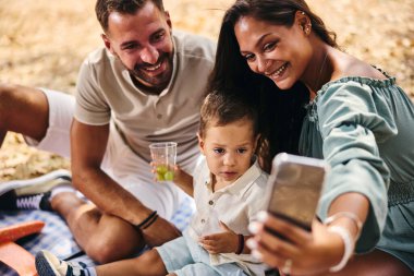 Mutlu aile parkta piknik yaparken selfie çekiyor.. 