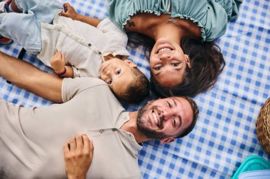 Mutlu aile uzanıyor, gülümsüyor ve doğada güzel bir günün tadını çıkarıyor.. 