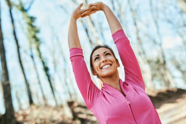 Yüzünde bir gülümsemeyle dışarıda uzanan güzel bir kadın..