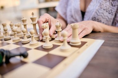 Bir kadın açık havada oynarken bir sonraki satranç hamlesini düşünür.. 