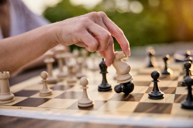 Satranç taşlarını açık hava tahtasına dikkatlice yerleştiren biri.. 