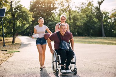 Aile parkta güneşli bir gün geçiriyor. Babasıyla tekerlekli sandalyede.. 