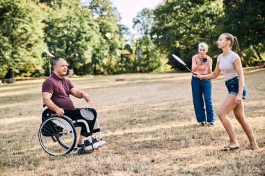 Mutlu bir aile güneşli parkta badminton oynarken eğleniyor.. 