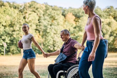 Mutlu bir aile parkta eğleniyor. Babam tekerlekli sandalyede.. 
