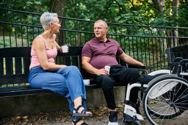 Yaşlı bir çift parktaki bankta keyifli bir sohbeti paylaşıyor, dışarıda kahvenin tadını çıkarıyorlar.. 