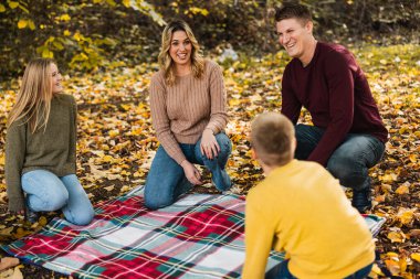 Dört kişilik aile güzel bir sonbahar gününde parkta piknik yapmaya hazırlanıyor.. 
