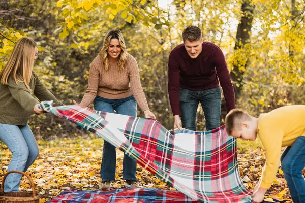 Dört kişilik aile güzel bir sonbahar gününde parkta piknik yapmaya hazırlanıyor.. 