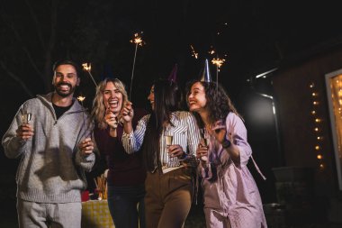 Mutlu arkadaşlar doğum gününü fıskiyelerle kutlar. Neşeli ve gülümserler..