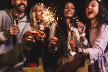 Mutlu arkadaşlar doğum gününü fıskiyelerle kutlar. Neşeli ve gülümserler..