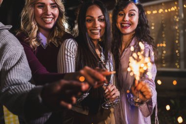 Mutlu arkadaşlar doğum gününü fıskiyelerle kutlar. Neşeli ve gülümserler..