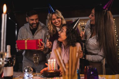 Kız arkadaşlarıyla doğum gününü kutlar, ona hediye verirler ve o da mumları söndürür..