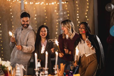 Mutlu arkadaşlar fıskiyelerle kutlarlar, neşeli ve gülümserler..