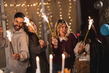 Mutlu arkadaşlar fıskiyelerle kutlarlar, neşeli ve gülümserler..