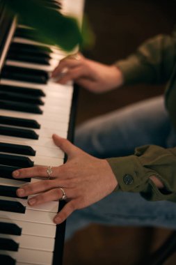 Tutkuyla piyano çalan, eğlenen ve evde bir anı yakalayan genç bir kadın.. 