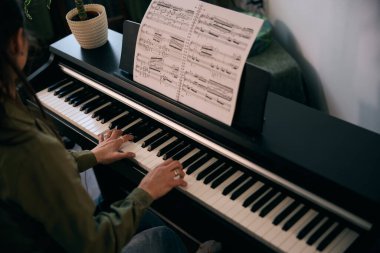 Tutkuyla piyano çalan, eğlenen ve evde bir anı yakalayan genç bir kadın.. 