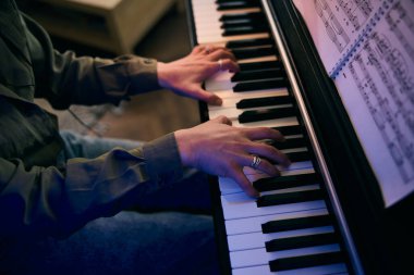 Genç kadın elleri evde tutkuyla piyano çalıyor..