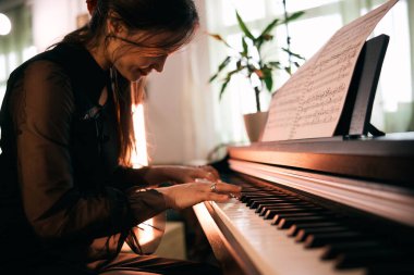 Evde tutkulu bir şekilde piyano çalan ve anın tadını çıkaran bir kadın.. 