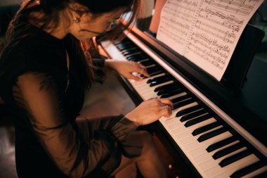 Woman playing a piano with passion at home and enjoying a moment. 