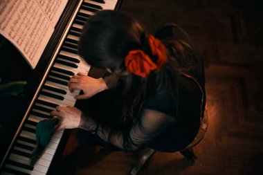 Kızıl saçlı güzel bir kadının evde tutkuyla piyano çalması.. 
