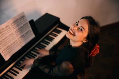 Gülümseyen bir kadının evde piyano çalması ve bir anın tadını çıkarması.. 