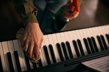 Kadın elleri piyanoyu derinden temizliyor. . 