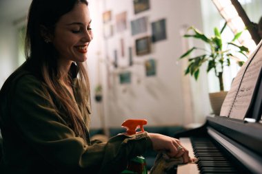 Güzel genç bayan sıcak evinde piyanoyu derinden temizliyor.. 