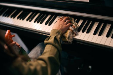 Kadın elleri piyanoyu derinden temizliyor. . 