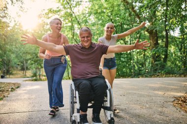 Mutlu bir aile güneşli bir günde parkta yürürken eğleniyor.. 