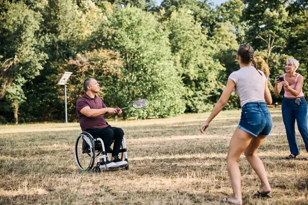 Mutlu bir aile güneşli parkta badminton oynarken eğleniyor.. 