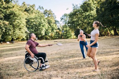 Mutlu bir aile güneşli parkta badminton oynarken eğleniyor.. 